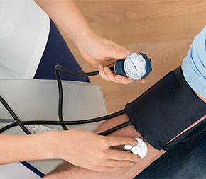medical professional uses blood pressure cuff on patient