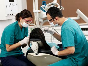 dental workers examining patient in chair