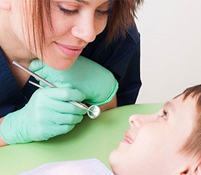 dental professional shows tools to young patient