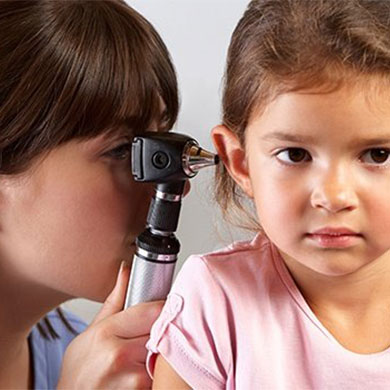 woman looking in child patient ear