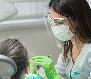 hygienist cleaning patient teeth
