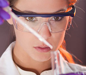 woman in lab putting fluid in vial