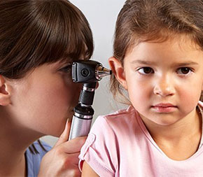 woman looking in child patient ear
