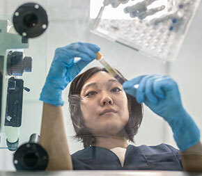 female lab tech examines specimen vial