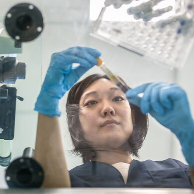 female lab tech examines specimen vial
