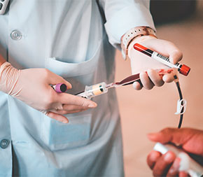close up of woman taking blood and filling vials