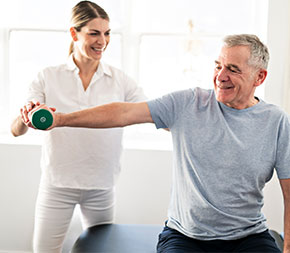woman pt helps male client with weights