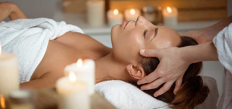 patient enjoying massage on table with candles and soft light