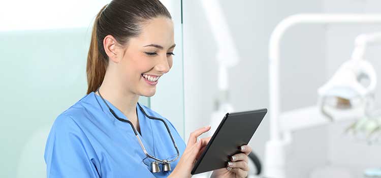 female medical assistant researching continuing education opportunities on handheld electronic device