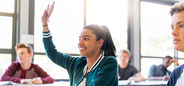 female student raising hand in classroom