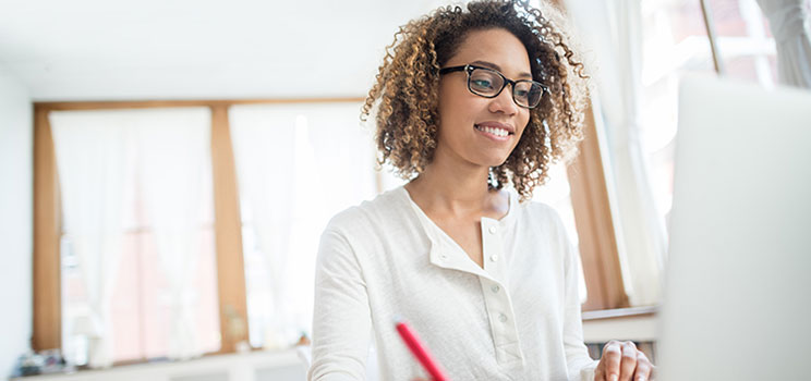 student writing notes from online lesson