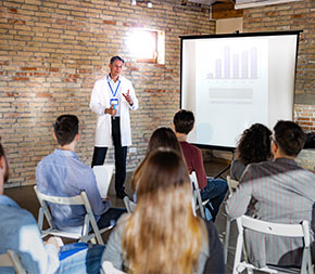 medical professional giving presentation of screen showing bar graph