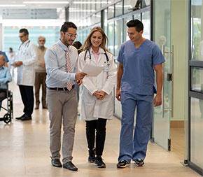 administrator walking with medical staff in hallway
