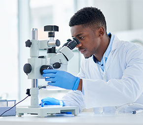 lab worker looking through microscope