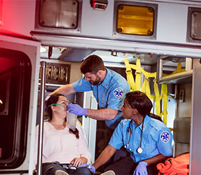 emergency medical technicians helping patient with oxygen mask