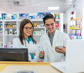 two pharmacy technicians review notepad in pharmacy