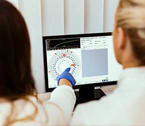 two medical professionals look at medicine test results on screen