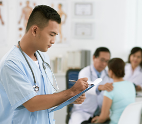 medical assistant taking notes while doctor sees patient