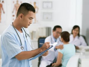 medical assistant taking notes while doctor sees patient
