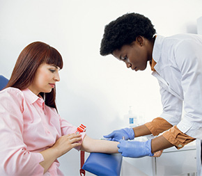 phlebotomist preparing to draw blood from patient