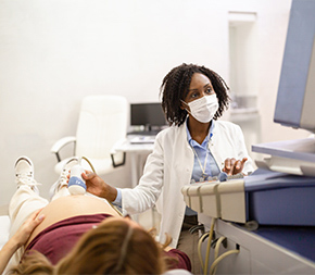 ultrasound technician scanning pregnant patient