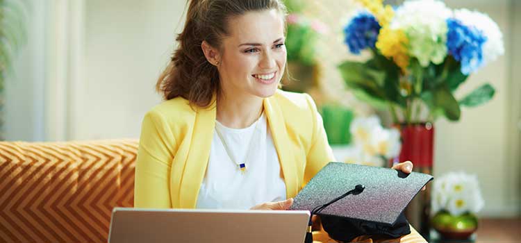 woman on couch holding graduation cap