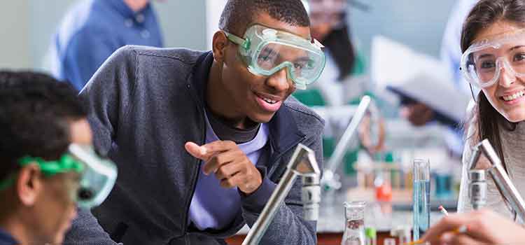 student in chemistry class surrounded by classmates