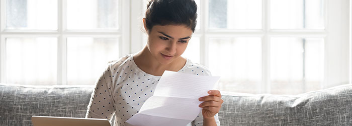 woman reads college admissions acceptance letter