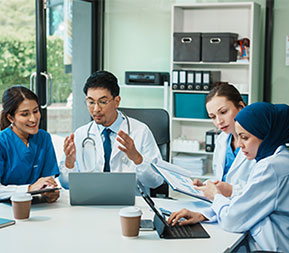 a group of healthcare managers and physicians collaborate on a project in a conference room
