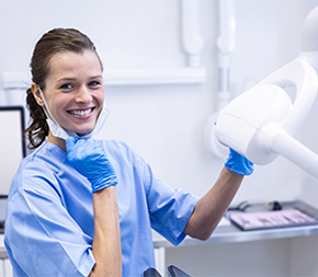 dental assistant in arkansas sets up x-ray machine for patient