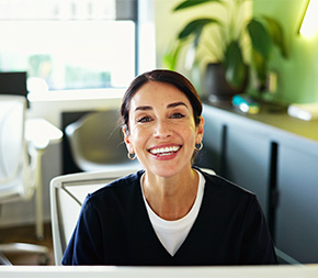 smiling medical office administrator greets a patient