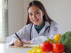 nutrition research intern writes in a notebook and looks at the camera