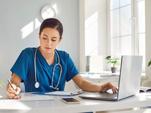 medical assistant student studies on her laptop