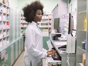 a pharmacy technician uses a computer in a pharmacy lab