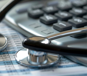 billing sheet with stethoscope and calculator on top of it.