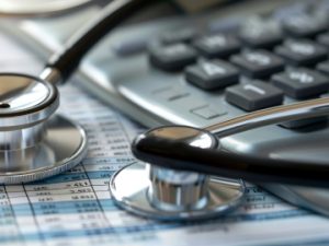 billing sheet with stethoscope and calculator on top of it