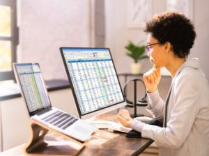 a medical coder works at a desktop computer inputting coding modifiers into reimbursement claims