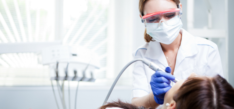 a dental hygienist cleans a young girl's teeth